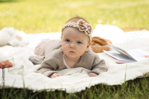 little girl lies on a blanket at a summer picnic photo