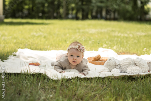 Obraz na płótnie little girl lies on a blanket at a summer picnic w salonie