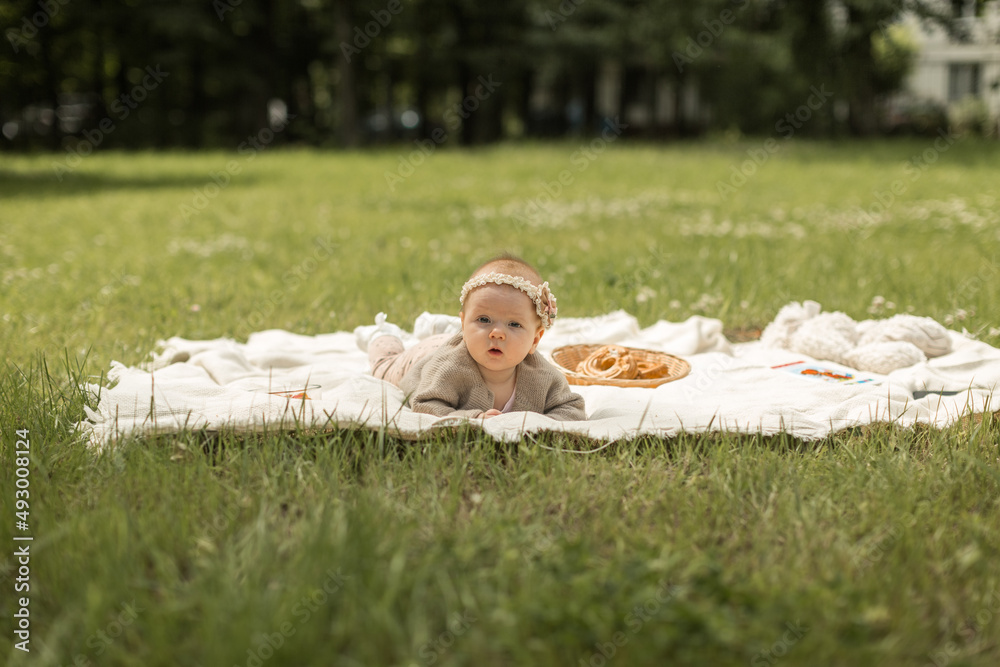 baby girl lies on a plaid, summer picnic for children
