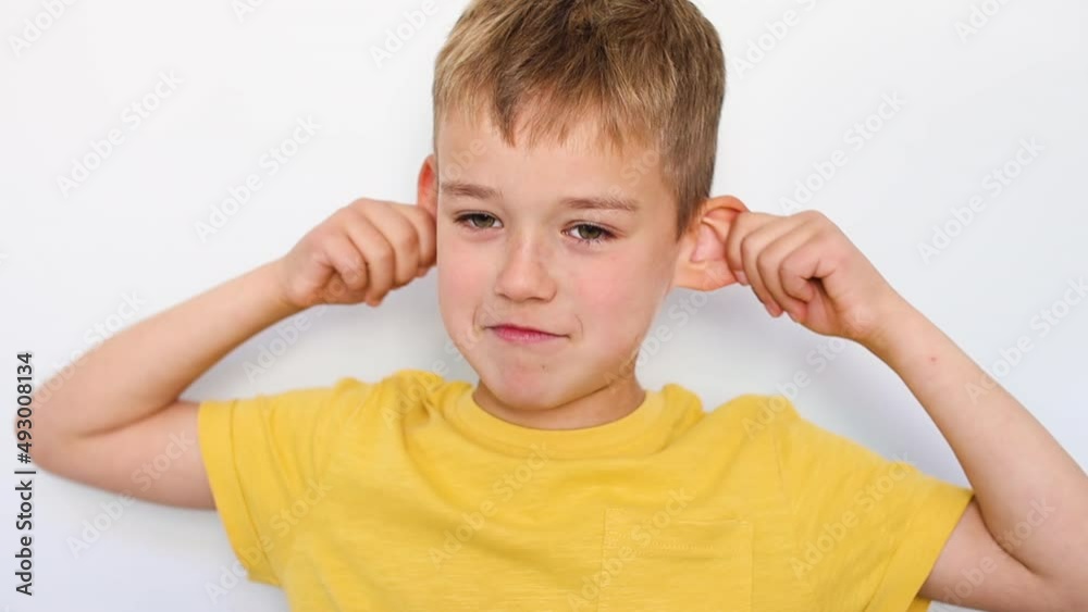 Boy making faces standing against the wall Boy making faces standing against the wall