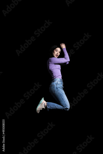 Fototapeta Naklejka Na Ścianę i Meble -  brunette woman jumping on black background