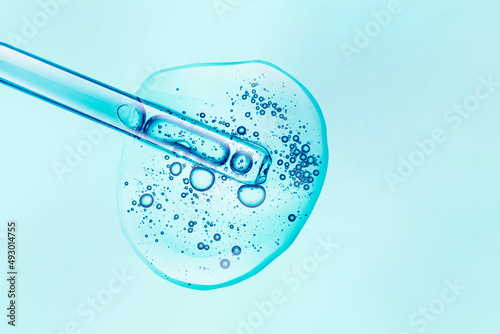 Liquid blue transparent gel or serum with dropper pipette texture background © tatyanarow