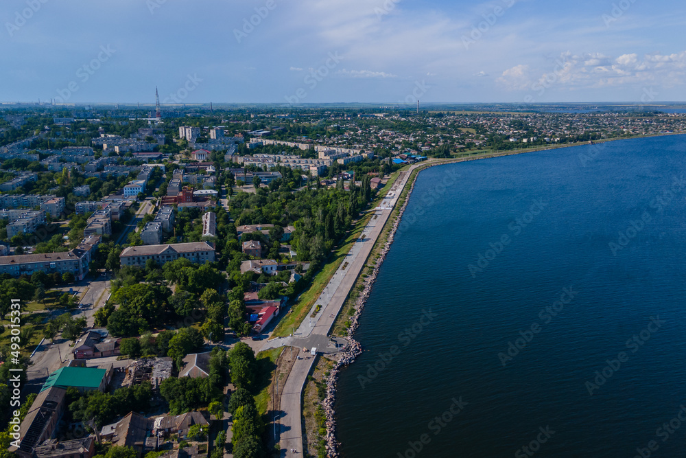 Kakhovskoye reservoir in the city of Nikopol. Ukraine. View from drone. Summer warm day. Place for a walk for adults and children near the water