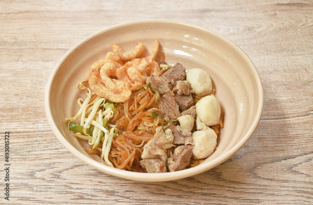 boiled dry thin rice noodles topping slice braised pork and meatball dressing sweet black soybean sauce on bowl boiled dry thin rice noodles topping slice braised pork and meatball dressing sweet black soybean sauce on bowl