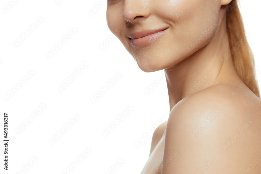 Naklejka premium Cropped image of tender female face, smile isolated over white studio background