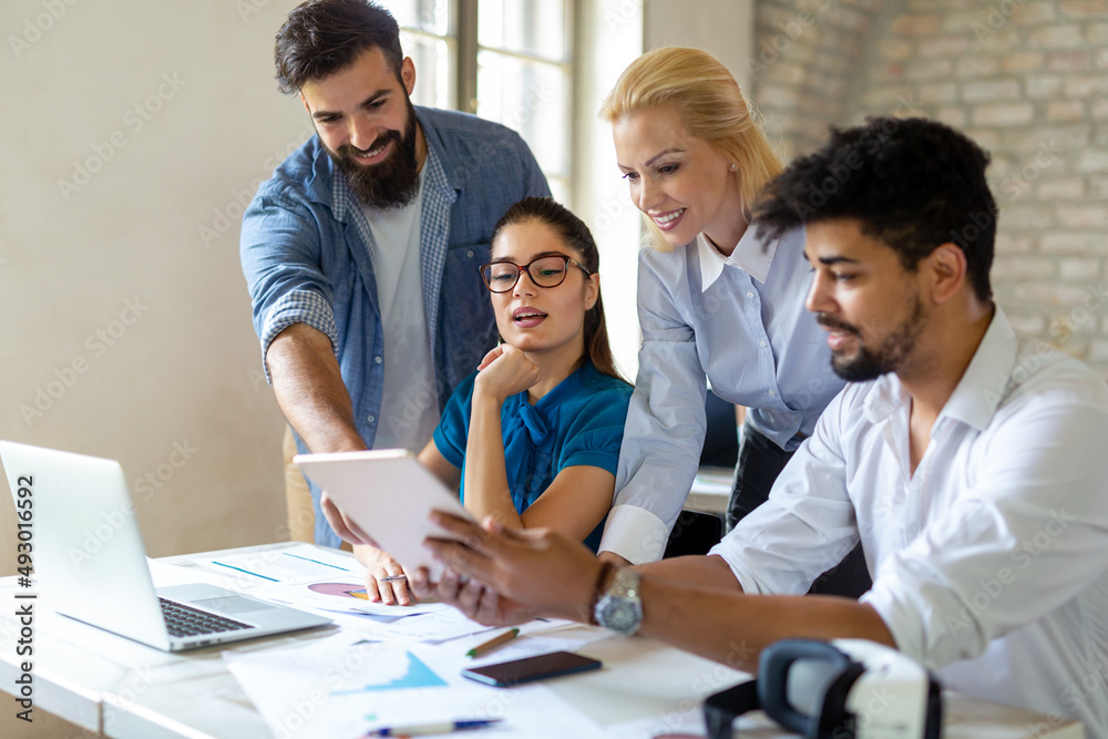 Working on new project together. Group of happy business people cooperating as a team in office Working on new project together. Group of happy business people cooperating as a team in office
