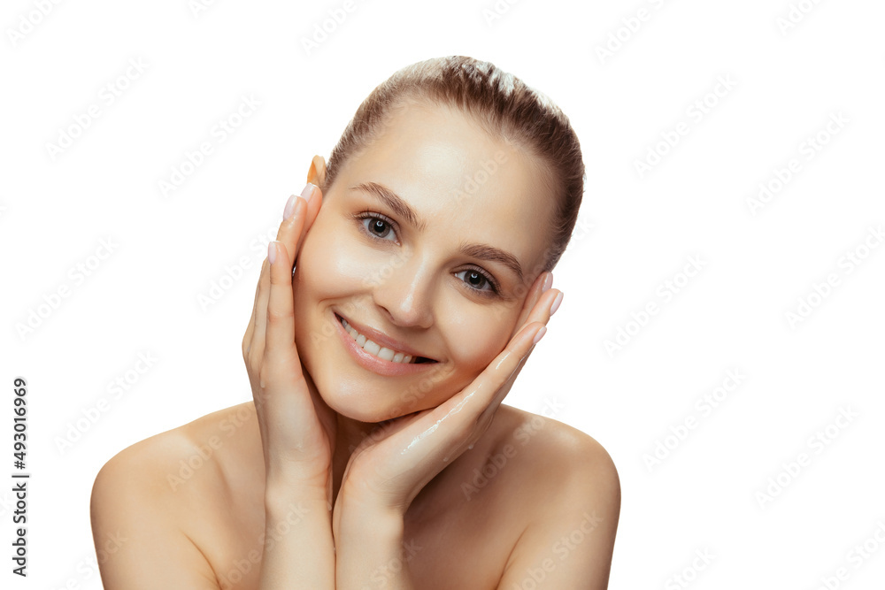 Portrait of young beautiful woman tenderly smiling, posing isolated over white studio background Portrait of young beautiful woman tenderly smiling, posing isolated over white studio background