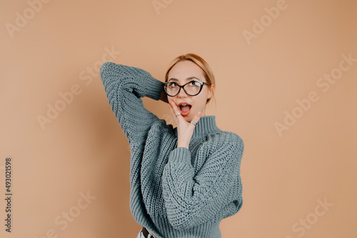 Blonde girl is making funny facies and having great time. Young woman looks cute. Concept of photography