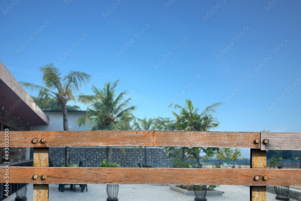 Wooden fence with an outside restaurant view with green plants and trees Wooden fence with an outside restaurant view with green plants and trees