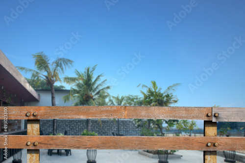 Wooden fence with an outside restaurant view with green plants and trees