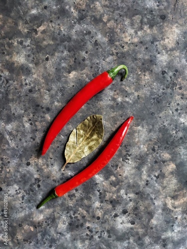 red hot chili peppers and bay leaf on black concrete background with copy space. Background of spices