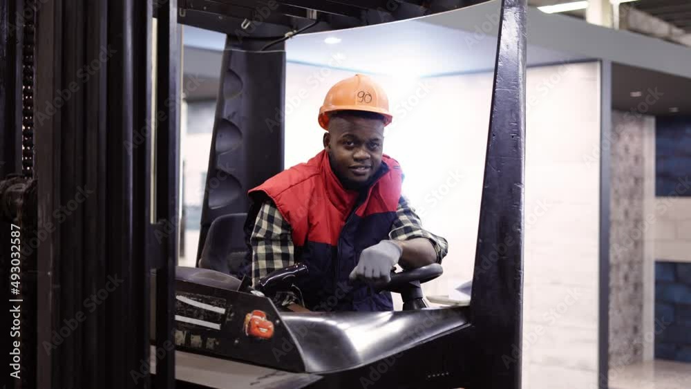 Portrait of forklift operator in the warehouse, wearing uniform