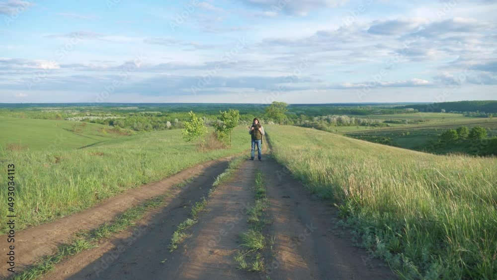 teamwork travel. man hiker with backpack walk along trail next to a field with green grass in nature. concept travel adventure hiking healthy. lifestyle tourist walk walking talking