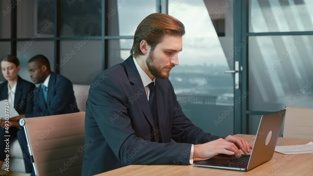 Working man in a suit with a laptop in the office. Young businessman
