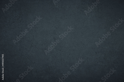 Dark gloomy blue and black slate background or texture with vignette
