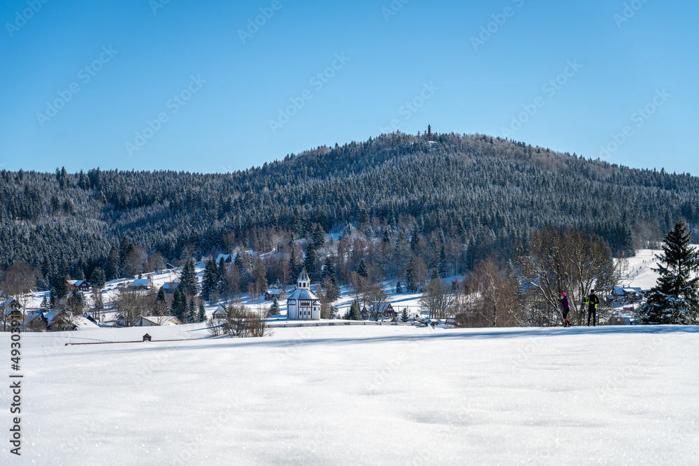 Wooden chapel and Stepanka lookout tower on background in wintertime