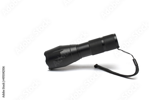 Closeup black aluminum flashlight outdoor white background