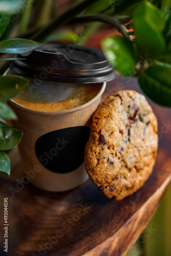 Takeaway coffee in a paper cup and delicious cookies. Close-up. Selective focus. Soft blurred background.