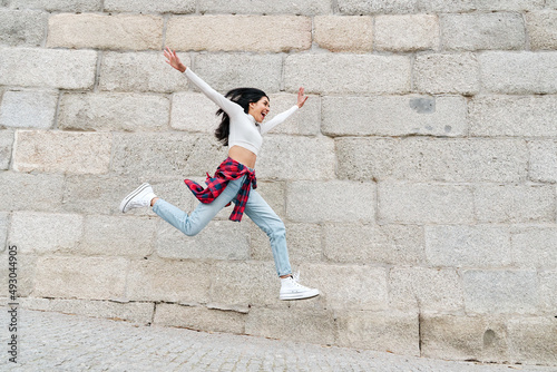 Woman jumping joyfully with open arms © Oscar