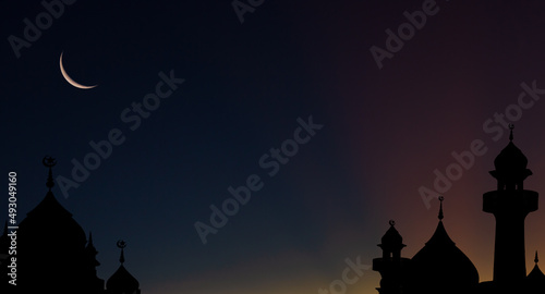 Mosques dome silhouette on dark blue twilight sky and crescent moon on background  symbol islamic religion Ramadan and free space for text arabic  Eid al-Adha  Eid al-fitr