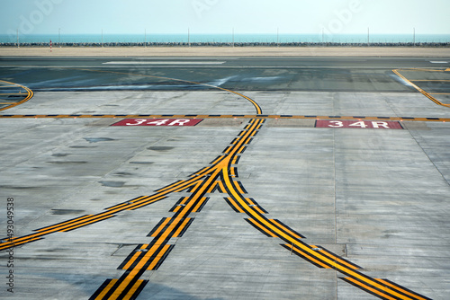 Curving yellow lines on the airport asphalt, with guidelines for taxiing aircraft.