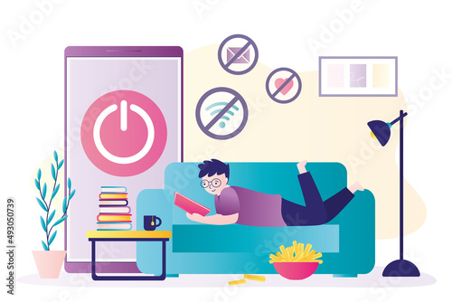 Boy lies on couch and reads interesting book. Refusal of gadgets. No internet addiction. Digital detox. Mobile phone with off button. Schoolboy is reading textbook. Pastime, leisure, hobby.