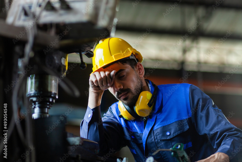 A male engineer or worker is stressed at work. heavy industrial plant concept