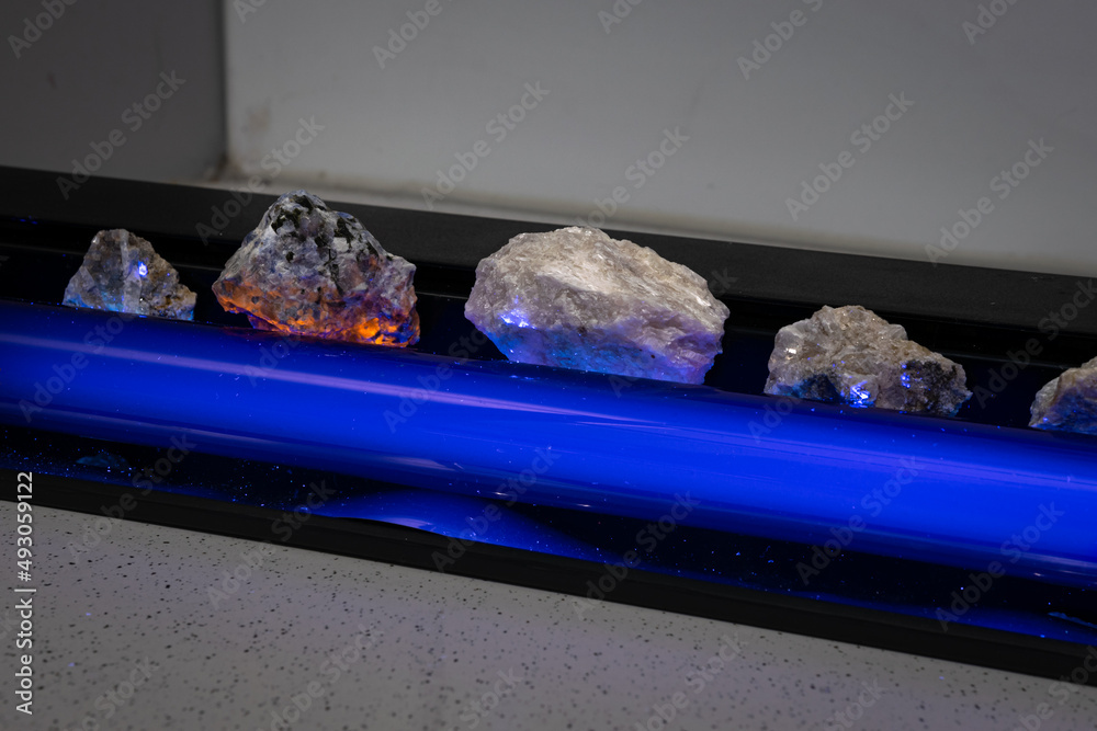 Stones in a laboratory are illuminated with an ultraviolet lamp, also