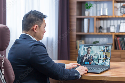 Male asian boss talking on video call with colleagues, online rally video call, boss working in classic office
