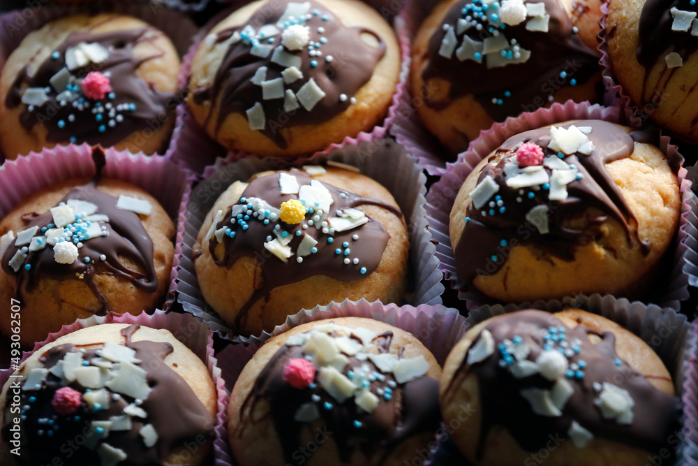 Muffins close-up with chocolate, colorful sugar sprinkles and decoration for children's party.