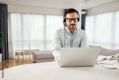 A customer support worker typing on the laptop and working from home.