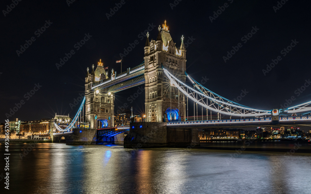 Fototapeta premium Tower Bridge in London at night. A reflection of the bridge in the Thames