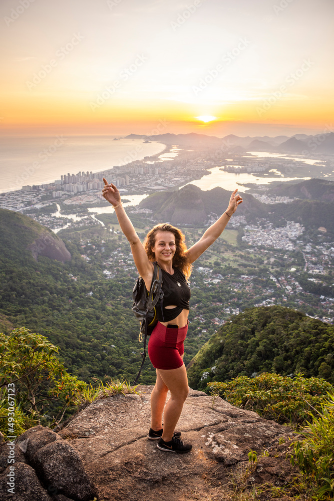 Beautiful sunset view to woman on rocky rainforest mountain Beautiful sunset view to woman on rocky rainforest mountain