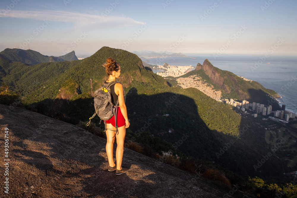 Beautiful sunset view to woman on rocky rainforest mountain