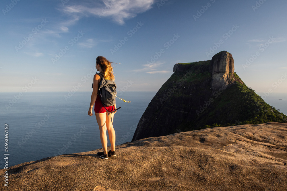 Beautiful sunset view to woman on rocky rainforest mountain