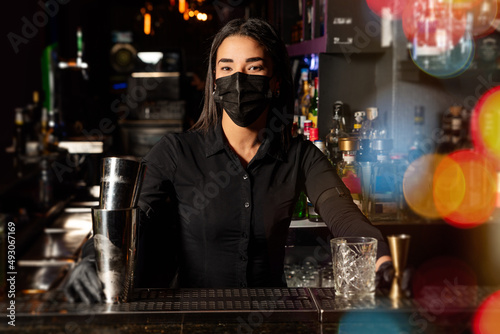 Latin brunette waitress prepares a cocktail at the bar. profession © Cavan