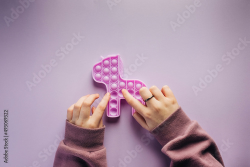 Overhead view of girl playing with a purple fidget toy photo