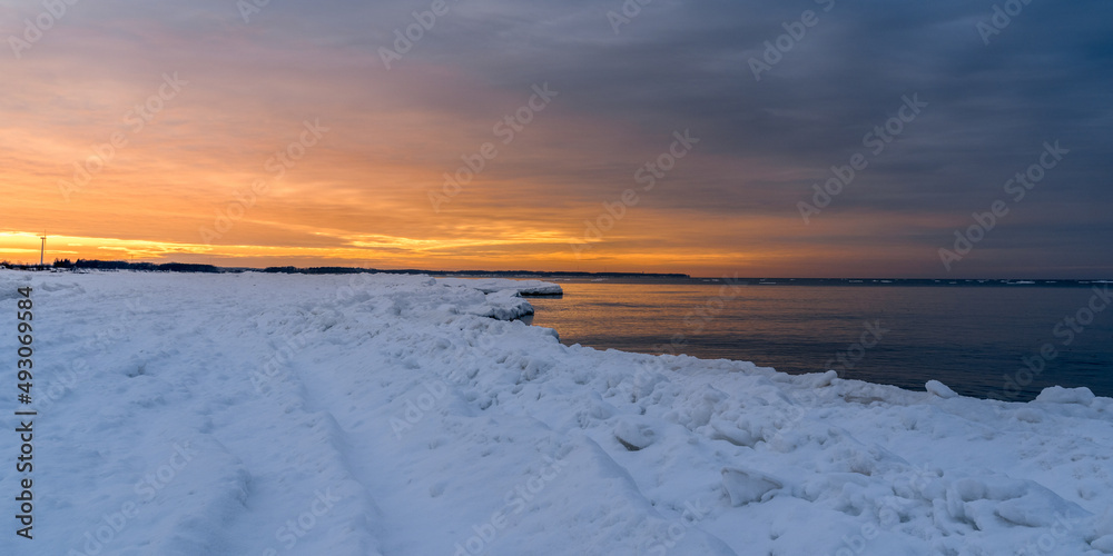 orange sunset on the snowy seashore