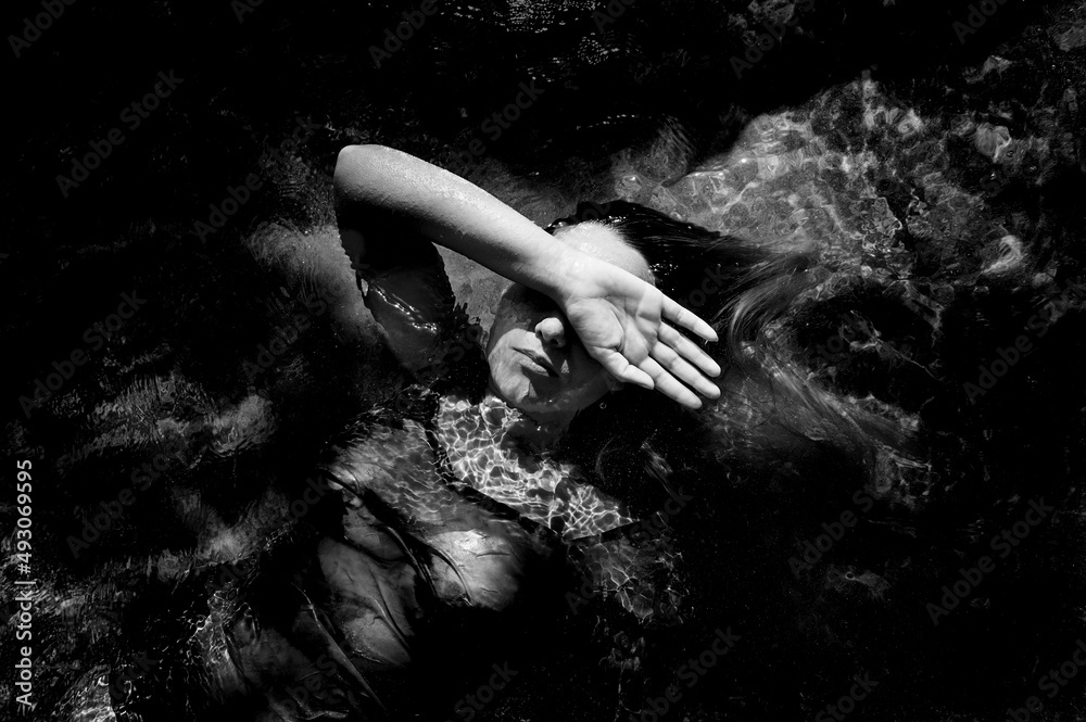 girl lying on the water covering part of her face with her hand Stock ...