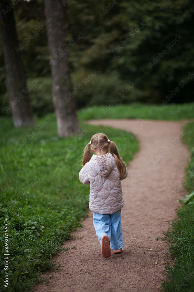 Small blonde european girl portrait with pig-tails with flowers in evening, outdoors, in forest. Big eyes and smart smile Small blonde european girl portrait with pig-tails with flowers in evening, outdoors, in forest. Big eyes and smart smile