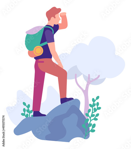 Traveler standing on rock and looking ahead. Man hiking