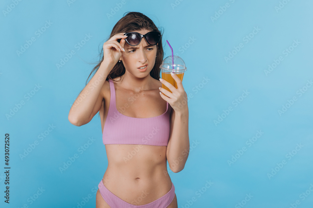 Young woman in swimsuit in summer holidays with a cocktail