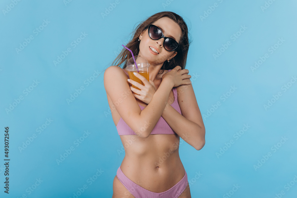 Young woman in swimsuit in summer holidays with a cocktail