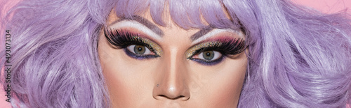 Konstfotografi partial view of drag queen in purple wig looking at camera, banner