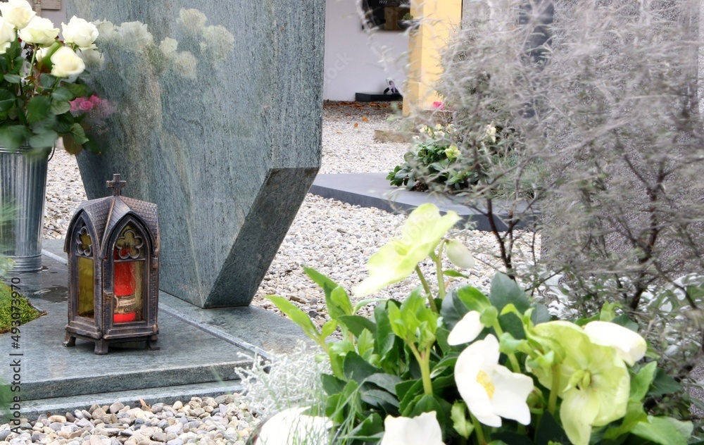 Grabgestaltung an einem katholischen Friedhof in Österreich mit Grablaterne, weißen Rosen und Schneerosen, Allerheiligen, Tod, Gedenken, Trauer