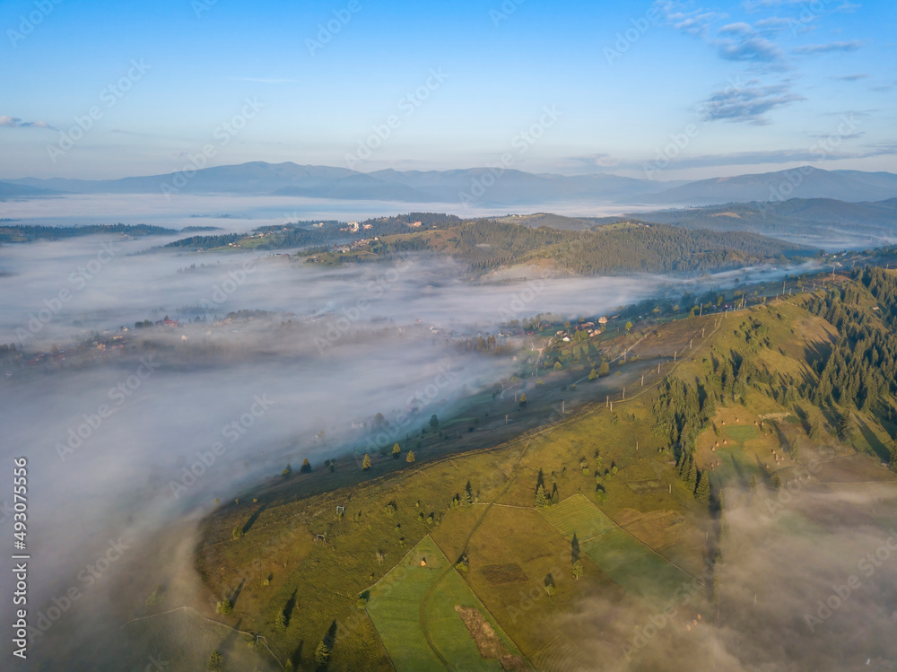 Green mountains of the Ukrainian Carpathians in the morning mist. Aerial drone view.