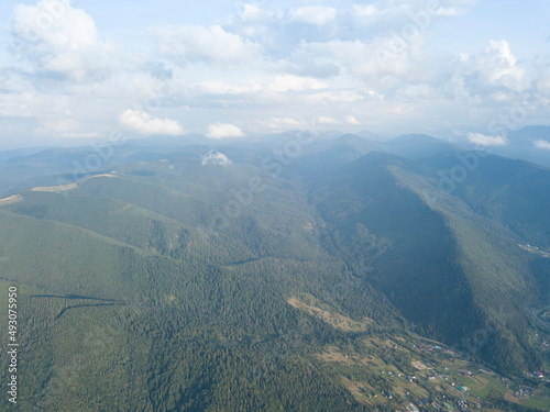 Green slopes of Ukrainian Carpathian mountains in summer. Cloudy day, low clouds. Aerial drone view. © Sergey
