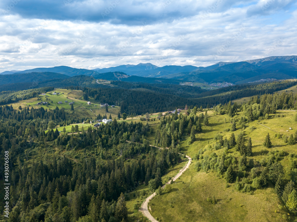 Green mountains of Ukrainian Carpathians in summer. Coniferous trees on the slopes. Aerial drone view.