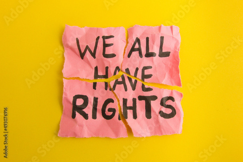Text we all have rights handwritten on torn paper note
