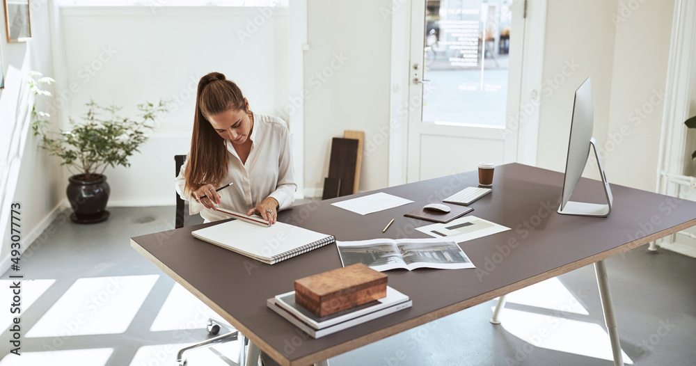 Young female architect measuring designs in a sketchbook Young female architect measuring designs in a sketchbook